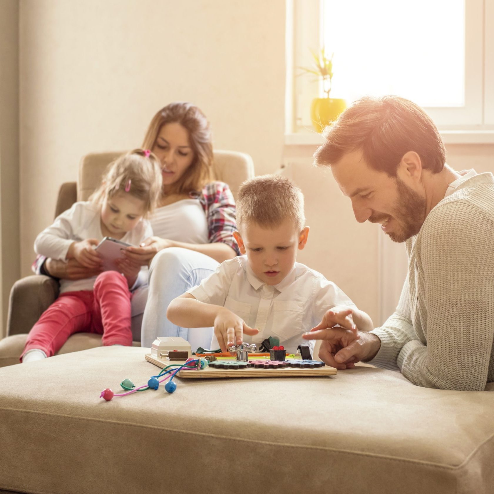 Shallow focus shot of a happy Caucasian family reading and playing